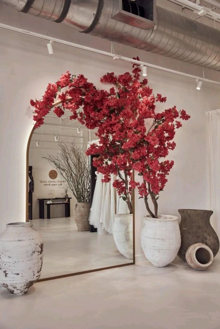 Statement bougainvillea specimen beside a tall arched mirror in a luxury interior